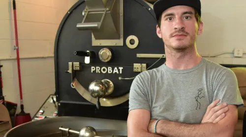 Man standing in front of coffee roaster.