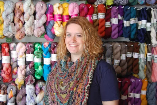 Rebecca Smith in front of yarn selection