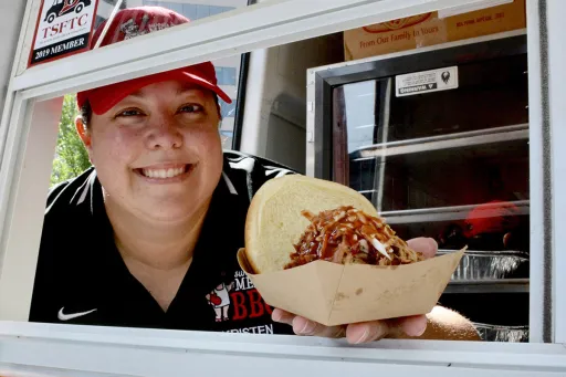 Image of Kristen Bailey holding a BBQ sandwhich