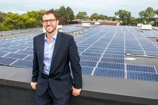 Business man stands in front of a rooftop display of proprietary fuel cells and solar panels